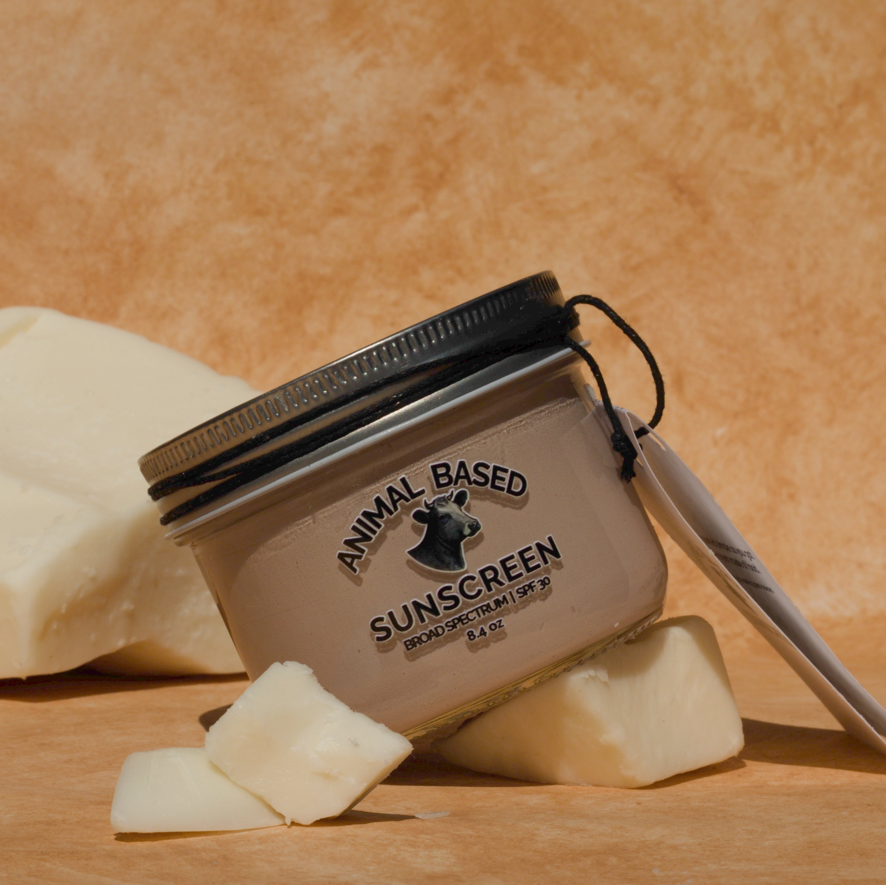 Jar of animal-based sunscreen with a beige background